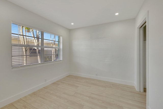 empty room with recessed lighting, baseboards, and light wood finished floors