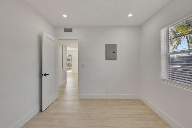 unfurnished room featuring recessed lighting, visible vents, light wood-style flooring, electric panel, and baseboards