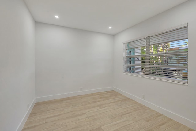 spare room featuring recessed lighting, light wood-type flooring, and baseboards