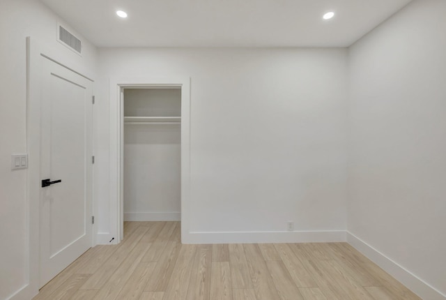 unfurnished bedroom with light wood-type flooring, baseboards, and recessed lighting