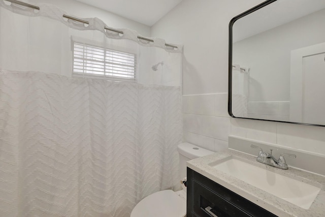 full bath with a shower with shower curtain, vanity, toilet, and tile walls