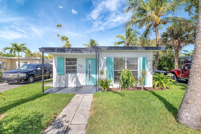 bungalow featuring a front lawn and stucco siding