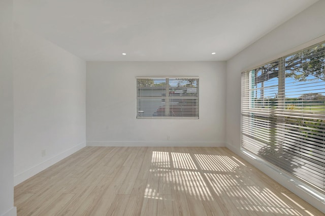 spare room featuring recessed lighting, baseboards, and wood finished floors