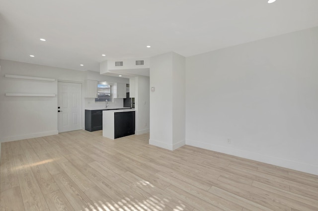 unfurnished living room with light wood-type flooring, baseboards, and visible vents