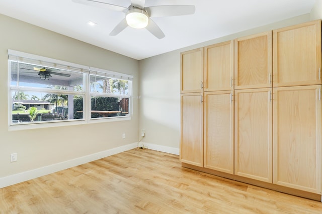 unfurnished bedroom with light wood-style floors, ceiling fan, and baseboards