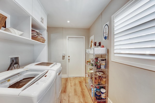 laundry area with washer and dryer, laundry area, and light wood finished floors