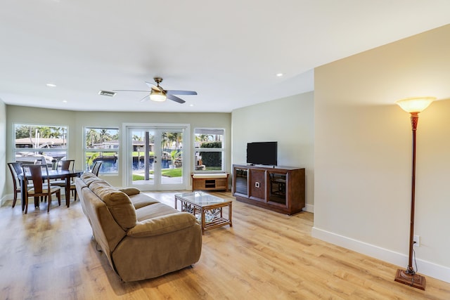 living room featuring french doors, light wood-style flooring, and baseboards