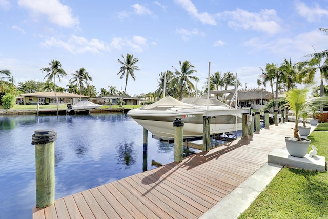 view of dock with a water view, boat lift, and a residential view