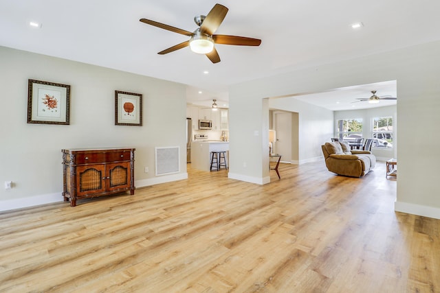 living area featuring light wood-type flooring, baseboards, visible vents, and recessed lighting