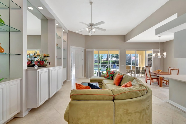 living area featuring light tile patterned floors, recessed lighting, built in features, and ceiling fan with notable chandelier