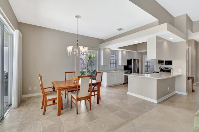 dining area featuring baseboards, visible vents, and a notable chandelier