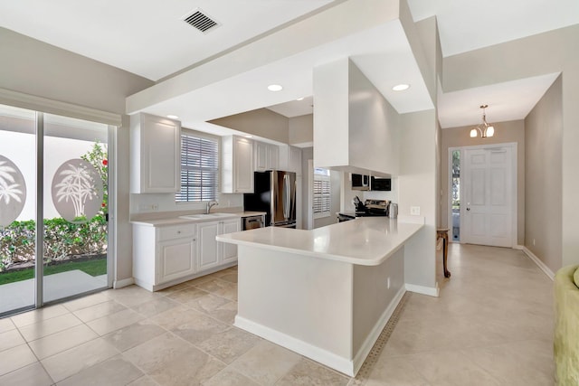 kitchen featuring light countertops, visible vents, appliances with stainless steel finishes, white cabinetry, and a sink