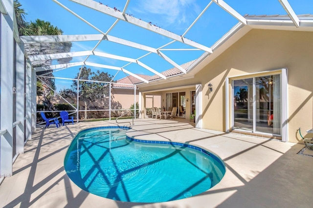 outdoor pool featuring glass enclosure and a patio area