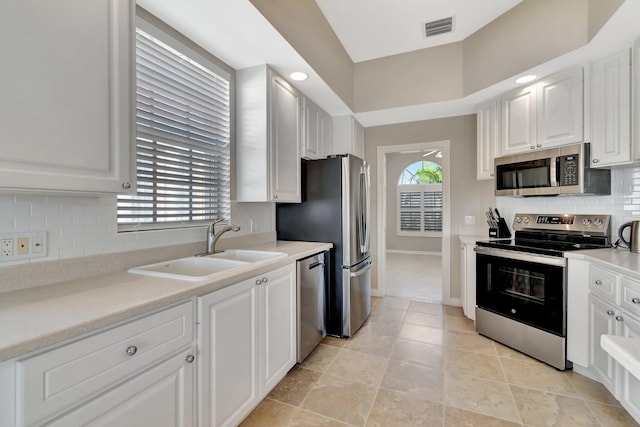 kitchen with appliances with stainless steel finishes, a wealth of natural light, visible vents, and a sink