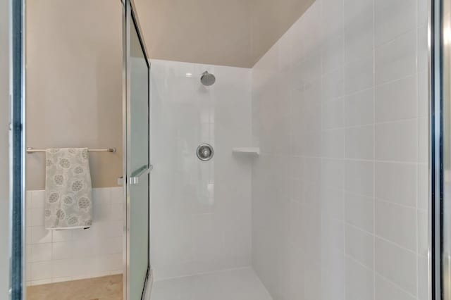 full bath featuring a stall shower and tile walls