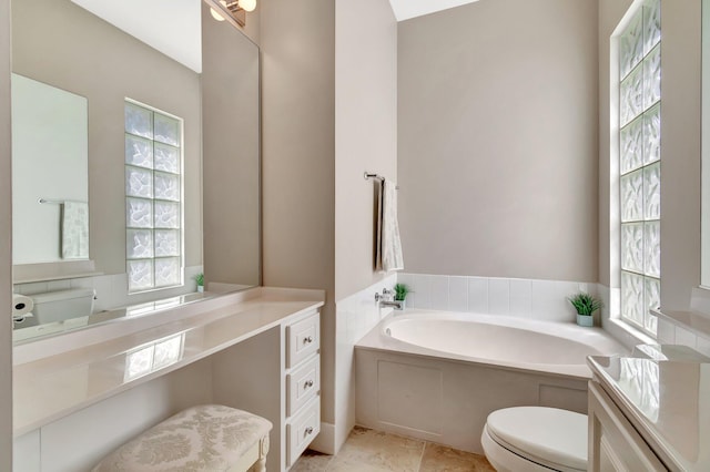 full bath with a garden tub, vanity, and toilet