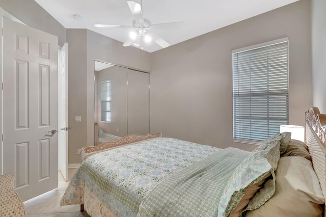 bedroom featuring a ceiling fan, a closet, and light tile patterned flooring