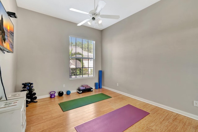 workout area featuring ceiling fan, baseboards, and wood finished floors