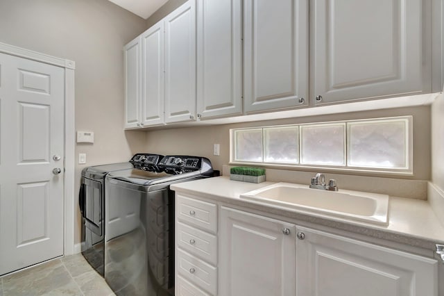 laundry area with washing machine and dryer, cabinet space, and a sink