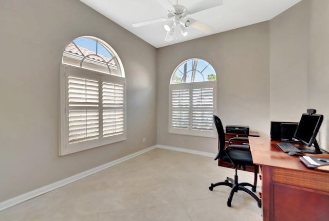 office space featuring a wealth of natural light, ceiling fan, and baseboards