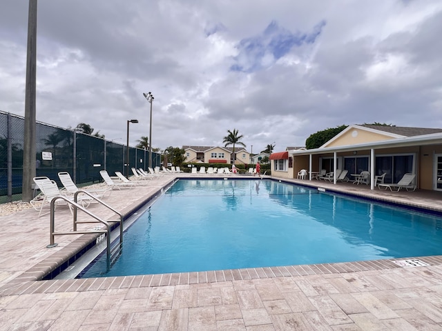 pool with a patio and fence