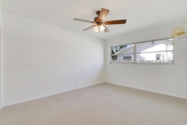 unfurnished room featuring carpet floors, a ceiling fan, and baseboards