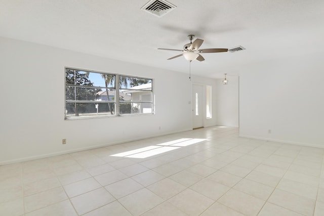 spare room with visible vents, ceiling fan, baseboards, and light tile patterned flooring