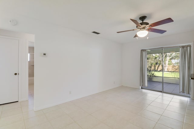 empty room with light tile patterned floors, visible vents, and a ceiling fan