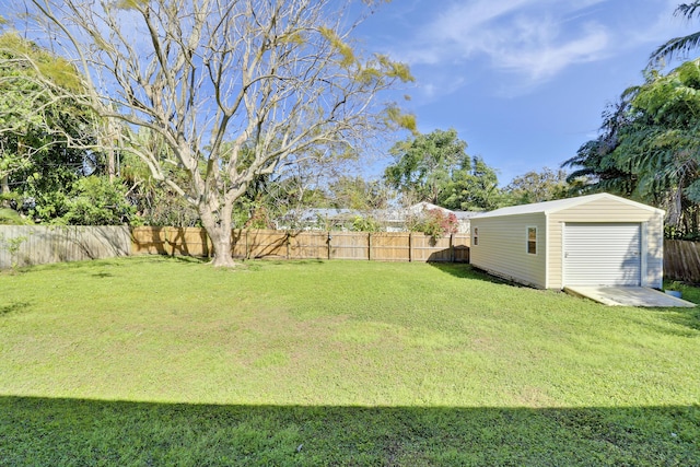 view of yard with a garage, an outbuilding, a fenced backyard, and a storage unit