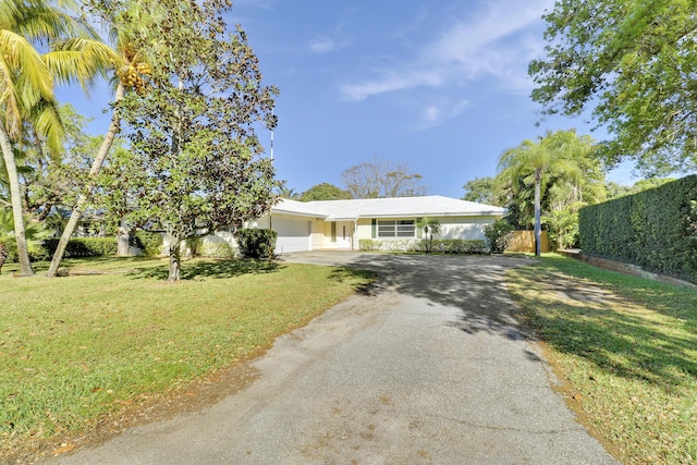 view of front facade with a garage, fence, a front lawn, and aphalt driveway