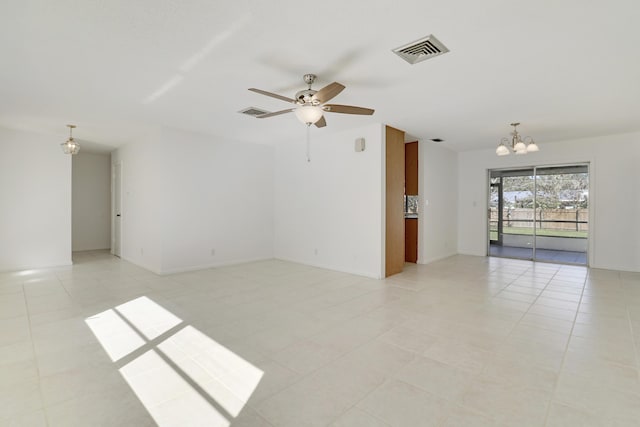 unfurnished room featuring light tile patterned floors, visible vents, and ceiling fan with notable chandelier