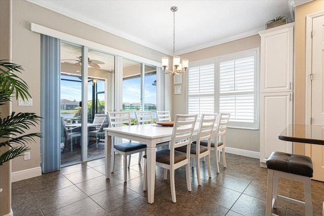 dining space with plenty of natural light, ornamental molding, baseboards, and dark tile patterned flooring