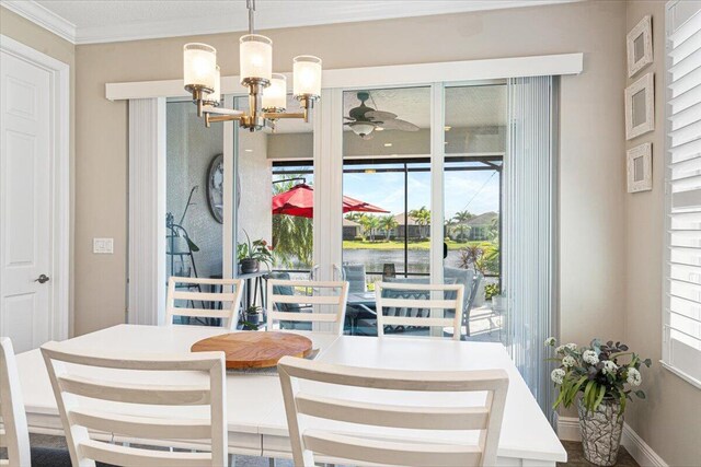 dining space featuring baseboards, ceiling fan with notable chandelier, and crown molding