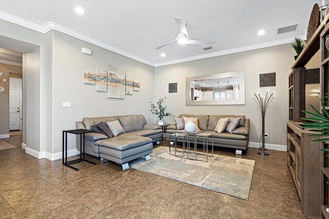 living room featuring baseboards, visible vents, a ceiling fan, ornamental molding, and a textured ceiling