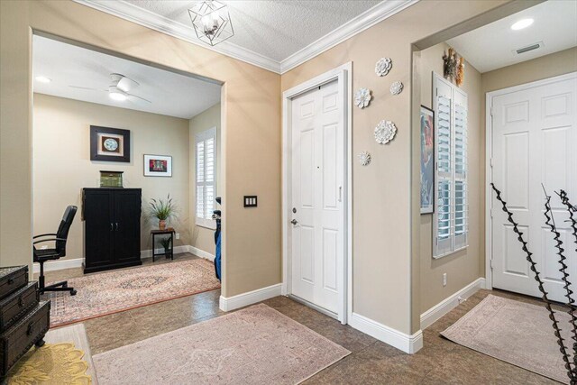 entryway with crown molding, visible vents, ceiling fan, a textured ceiling, and baseboards