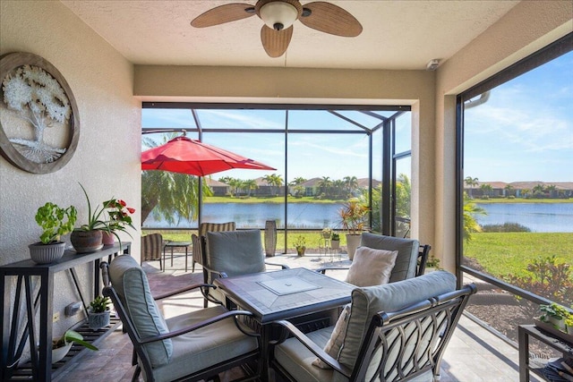 sunroom featuring a water view and ceiling fan