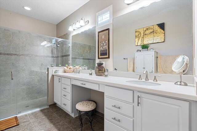 bathroom with double vanity, a stall shower, and a sink