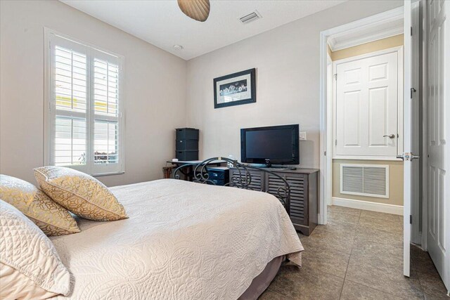 tiled bedroom featuring visible vents, ceiling fan, and baseboards