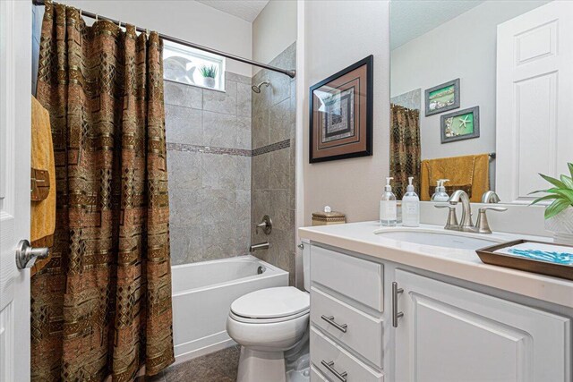 full bath with toilet, shower / bath combo, a textured ceiling, and vanity