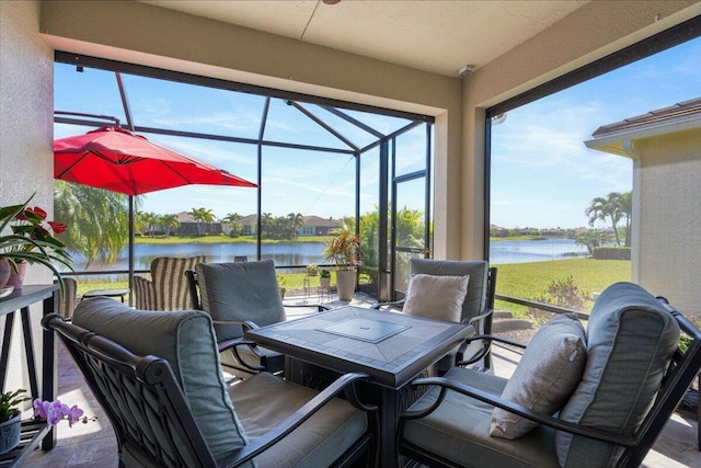 view of patio / terrace featuring glass enclosure and a water view