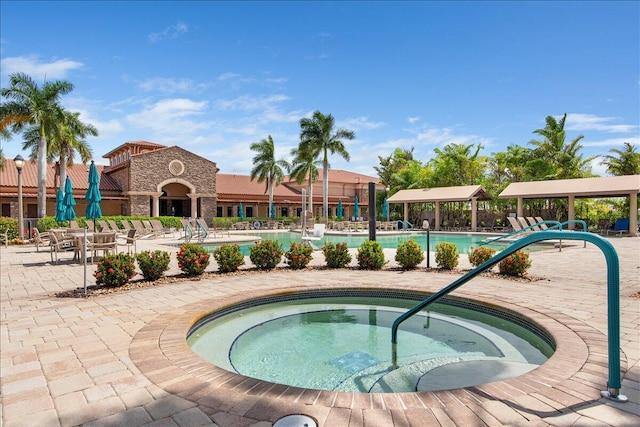 community pool featuring a community hot tub and a patio area