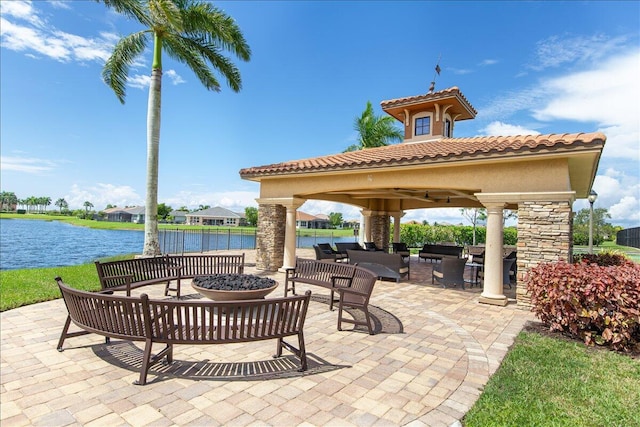 view of patio featuring a gazebo, a water view, and an outdoor living space with a fire pit