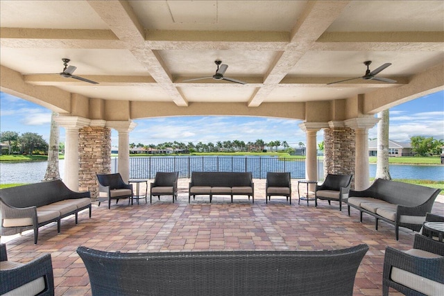 view of patio with outdoor lounge area, fence, and a water view