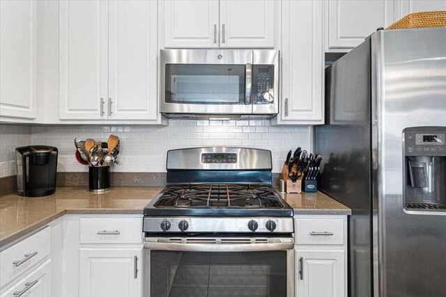 kitchen featuring appliances with stainless steel finishes, white cabinetry, and tasteful backsplash