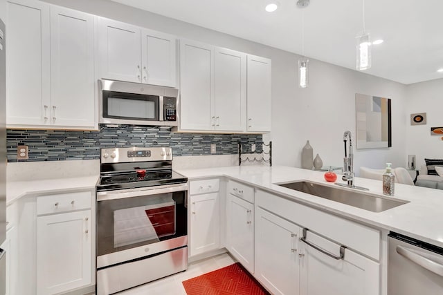 kitchen featuring backsplash, light countertops, light tile patterned floors, appliances with stainless steel finishes, and a sink