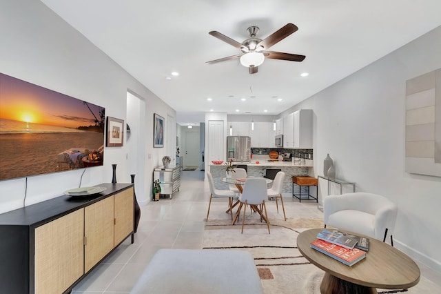 living area featuring light tile patterned floors, baseboards, ceiling fan, and recessed lighting