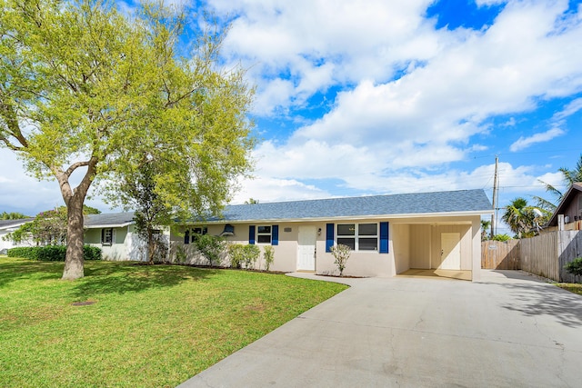 single story home featuring fence, concrete driveway, stucco siding, a carport, and a front lawn