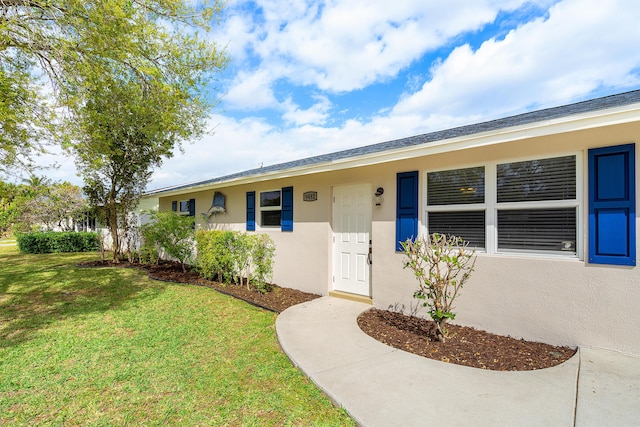 view of front of house with a front yard and stucco siding