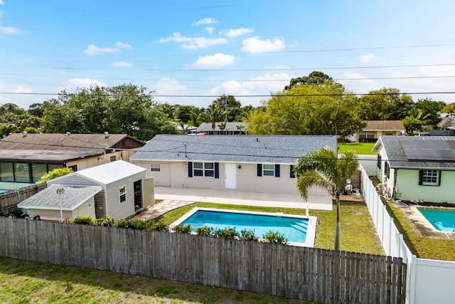 rear view of house with a fenced backyard, a fenced in pool, a patio, and a yard