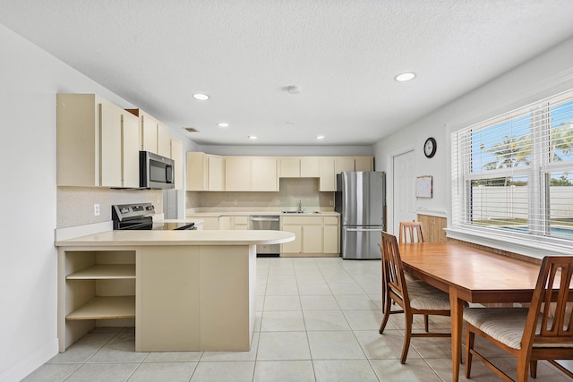 kitchen with open shelves, light countertops, decorative backsplash, cream cabinets, and appliances with stainless steel finishes